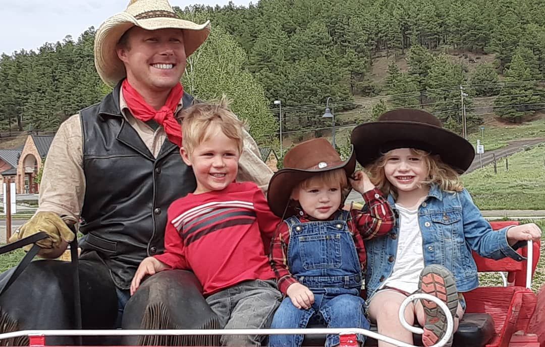 Cowboy with three kids on a horse-drawn carriage